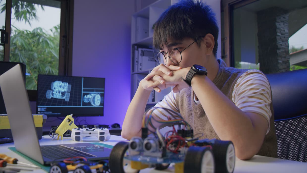 A stock photo of a young man looking at a laptop while being focused